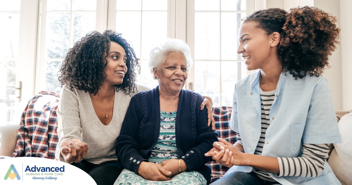 A caregiver talks with a client and her daughter, representing the type of communication that is vital when taking on a person-centered care approach.