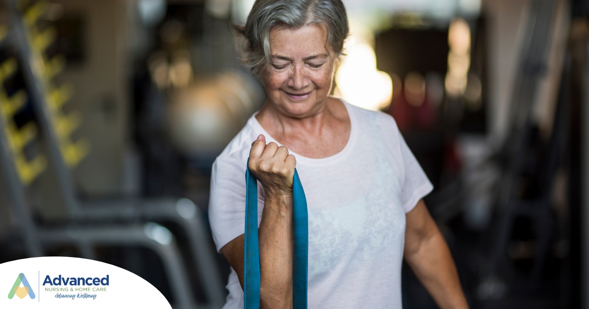An older woman uses a resistance band to exercise, representing how staying active can help older adults keep their blood pressure in a healthy range.