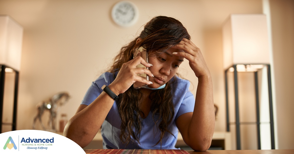 A nurse makes a call while looking extremely exhausted representing the bad effects of nurse burnout.