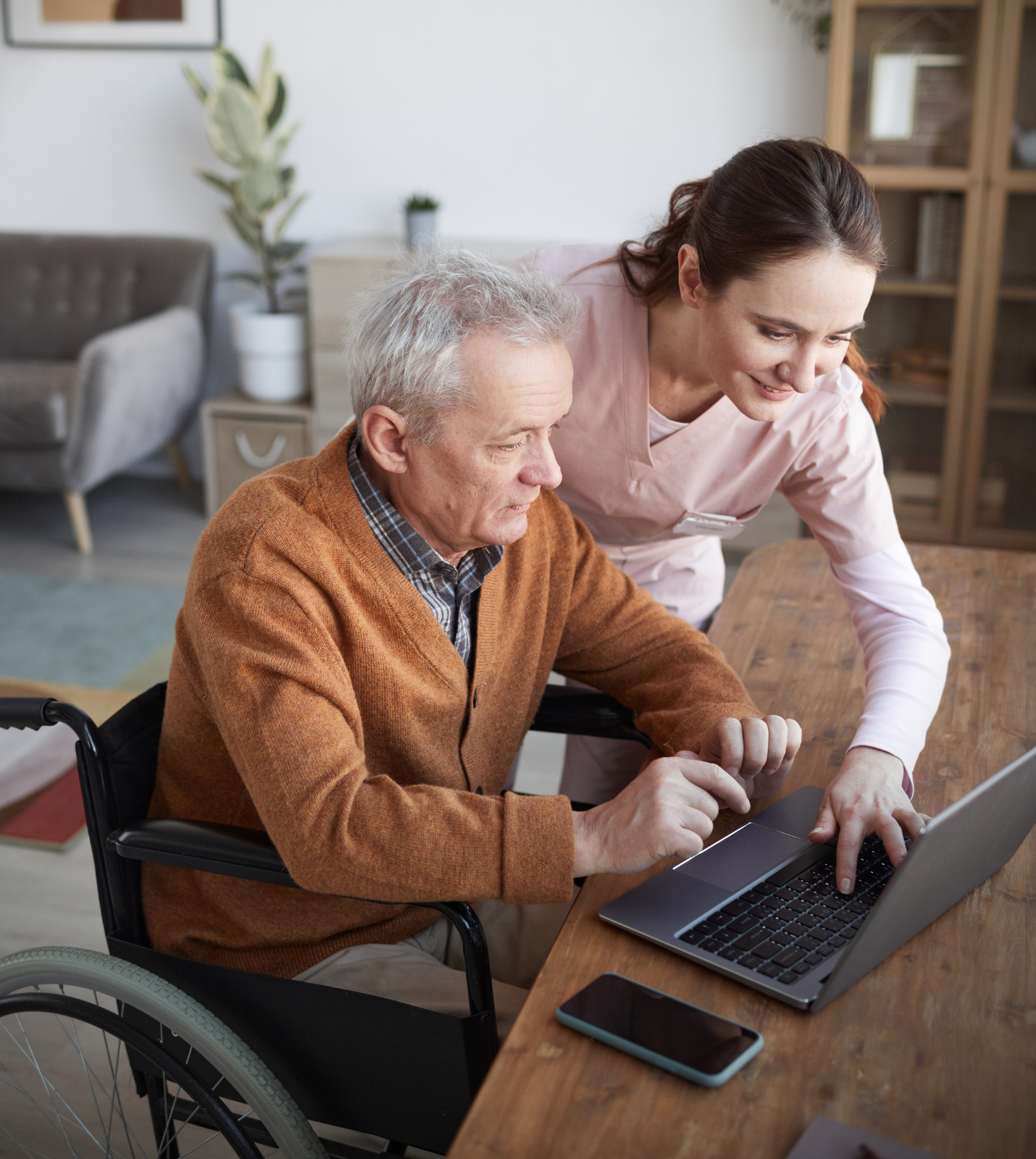 Caregiver assisting older adult with technology Caregiver assisting older adult with technology