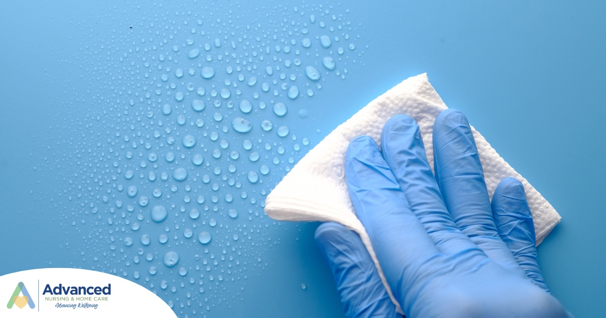 A gloved hand wipes down a surface, representing hygiene and practices that home health workers should employ.