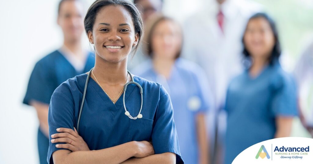 A woman in scrubs with a healthcare team behind her represents starting a new home health care job with a confident approach.