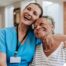 Young home health care nurse helping senior man to recover at home.