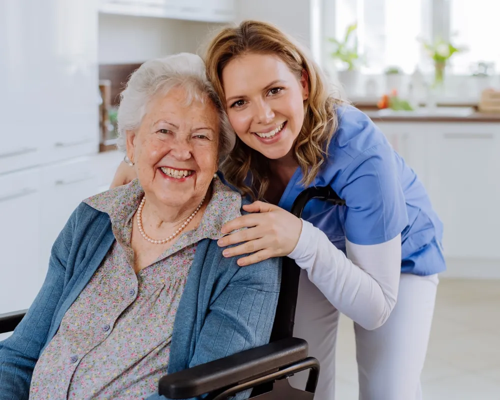 Caregiver and smiling senior woman in wheelchair