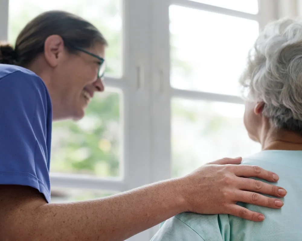 Caregiver comforting senior woman