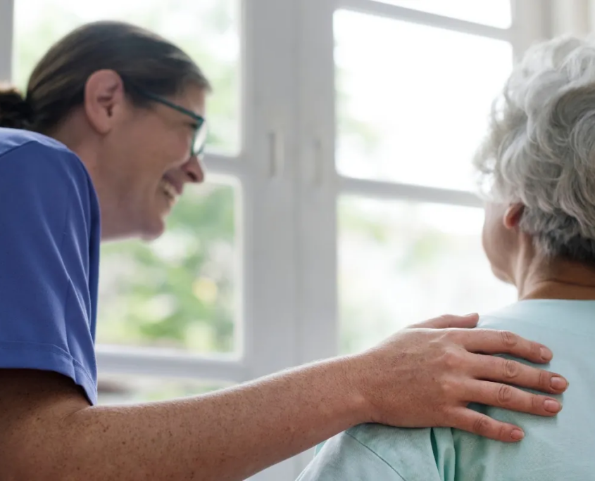 Caregiver comforting senior woman