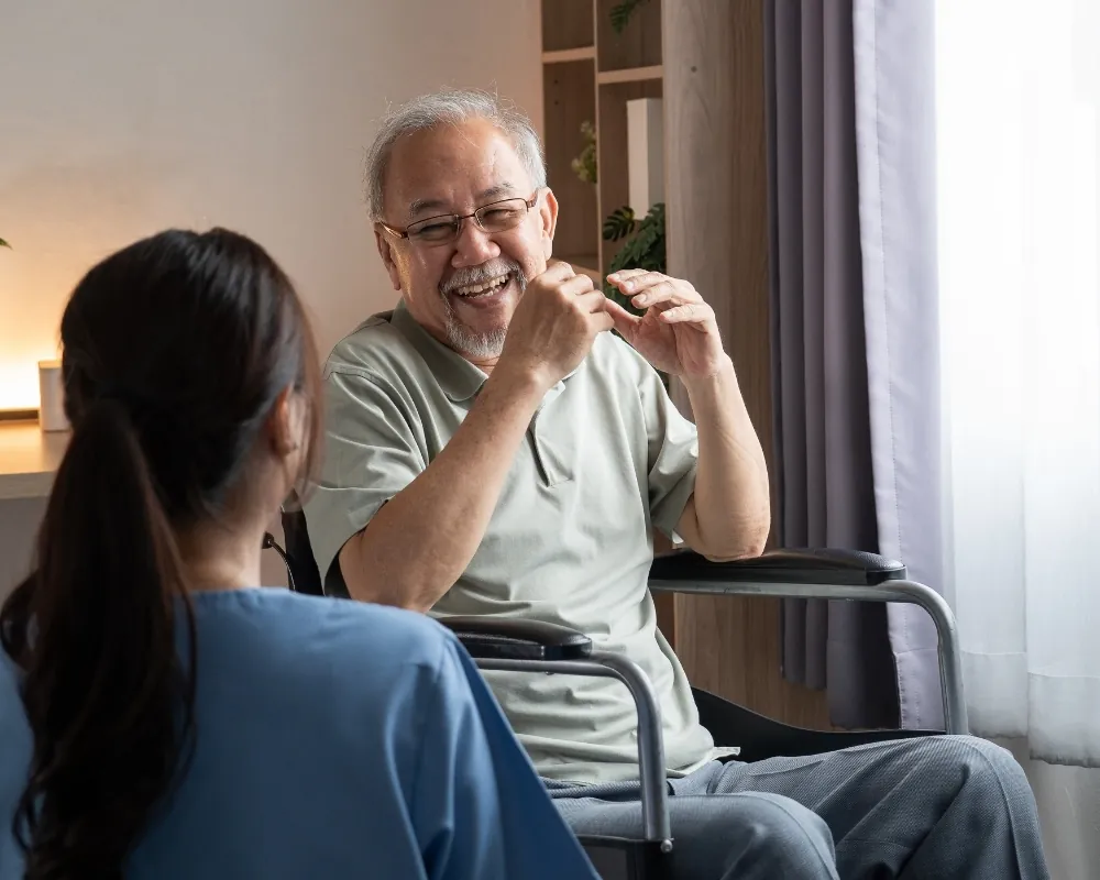Caregiver talking with senior man in wheelchair