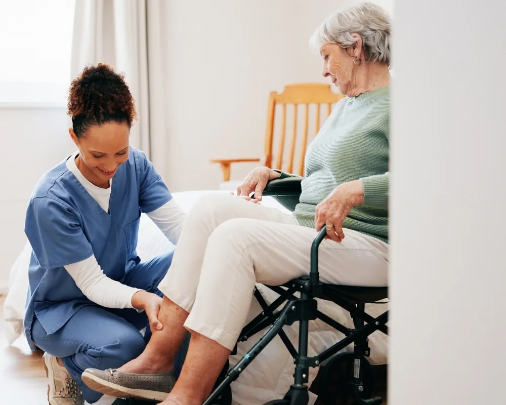 Caregiver helping senior woman in wheelchair