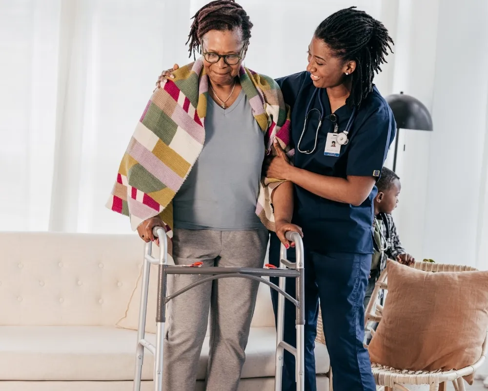 Caregiver helping senior woman with walker