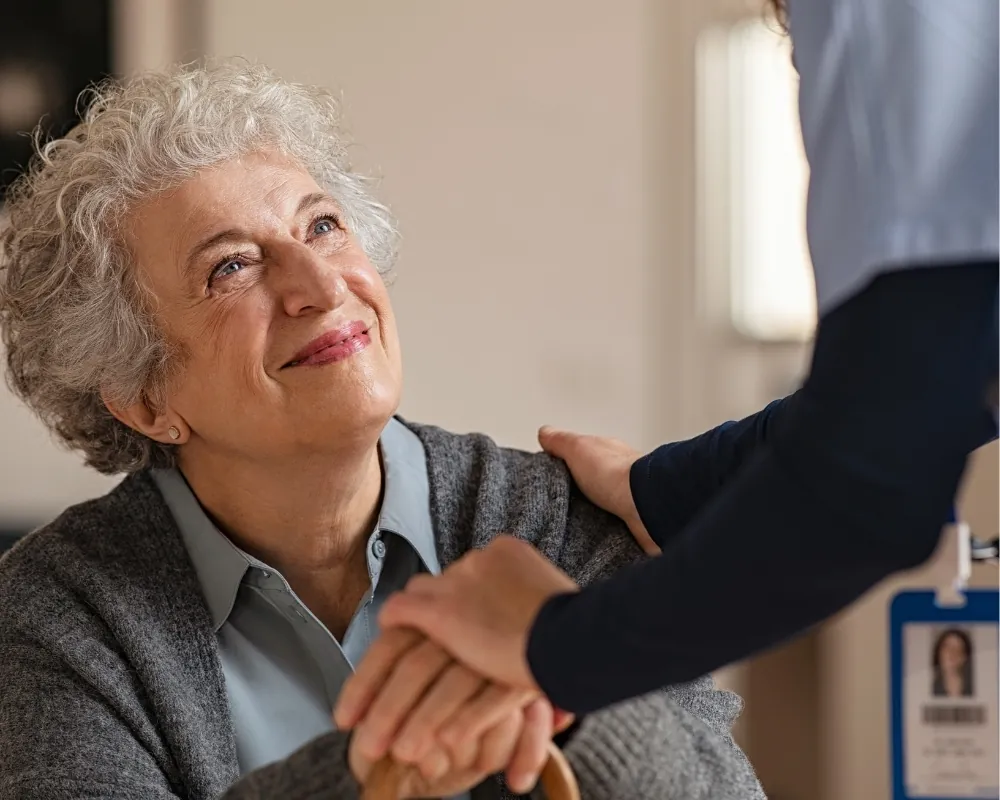 Caregiver holding hands with senior woman