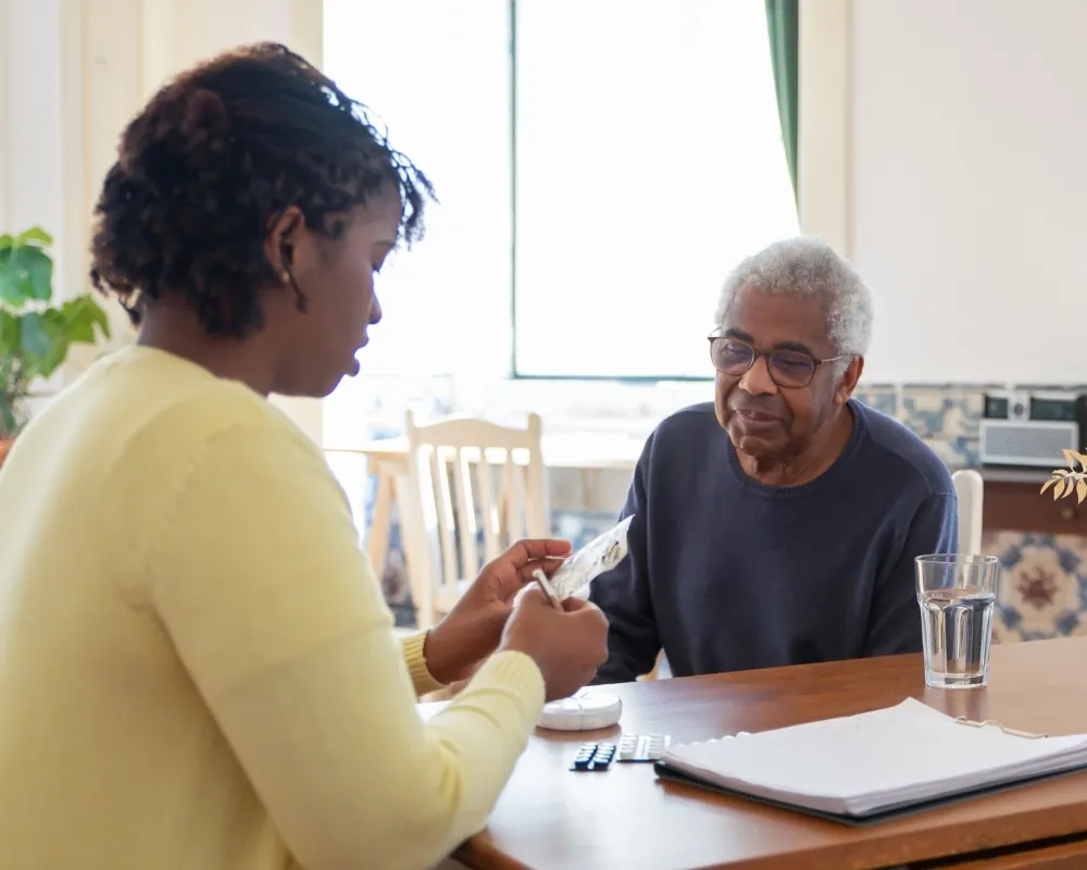 Caregiver giving senior man a medication reminder