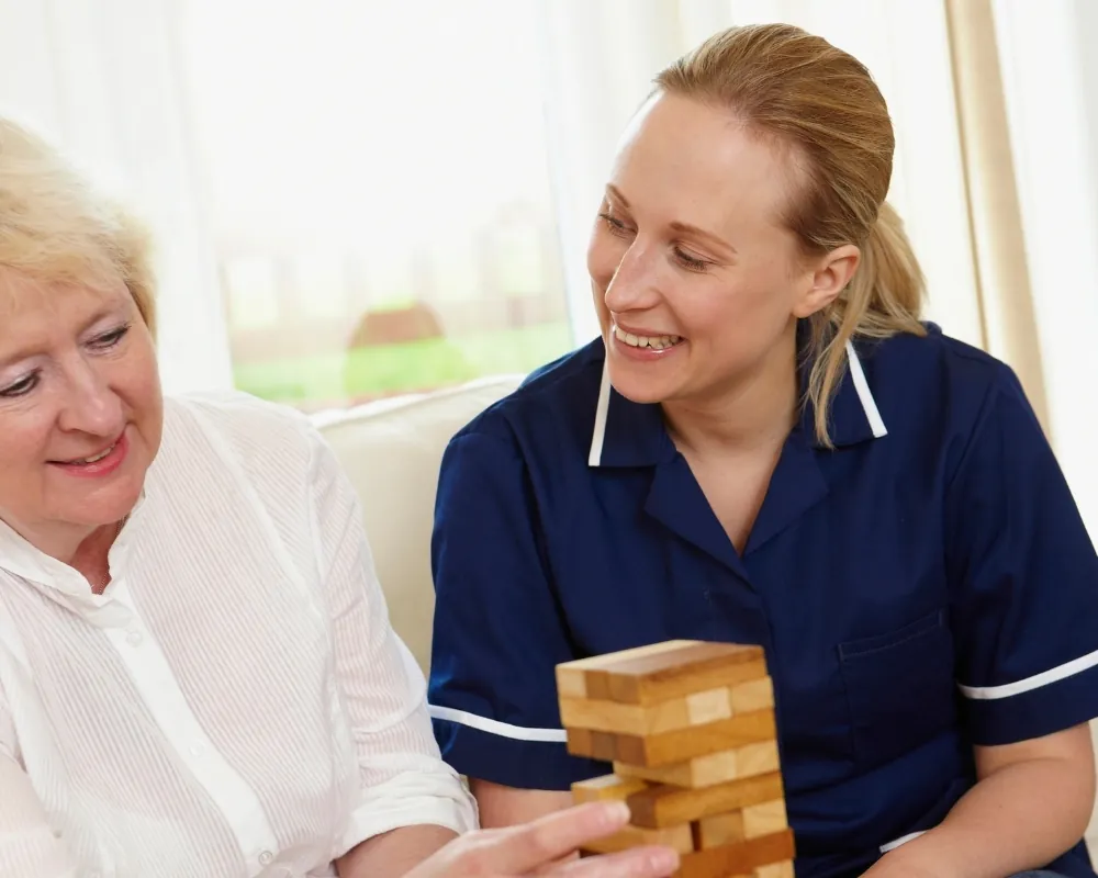 Caregiver playing block stacking game with senior