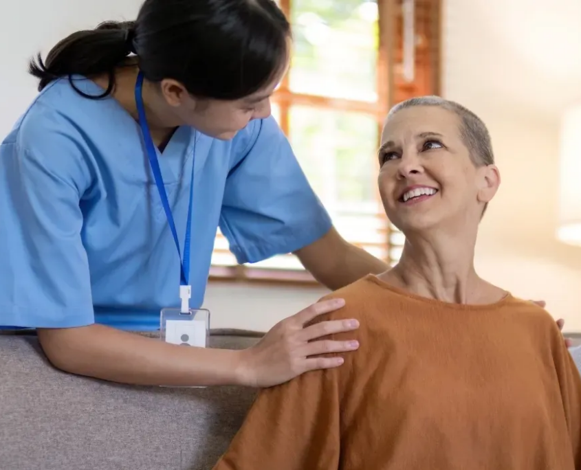 Caregiver reassuring woman on sofa