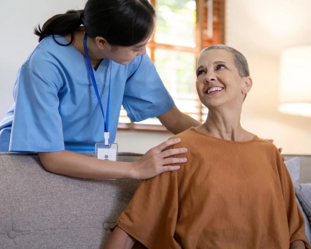 Caregiver reassuring woman on sofa
