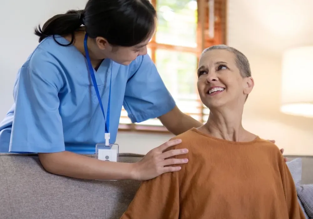 Caregiver reassuring woman on sofa