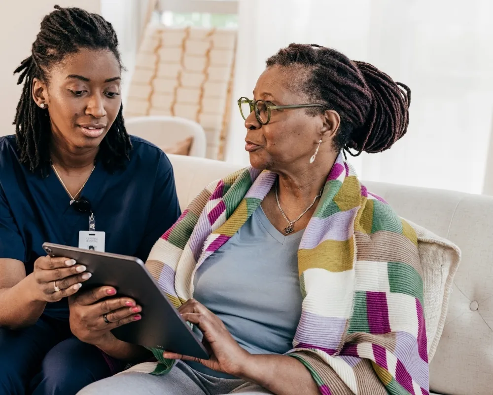 Caregiver showing tablet to senior woman
