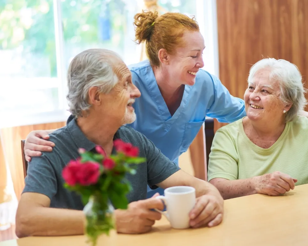 Caregiver with senior couple at table
