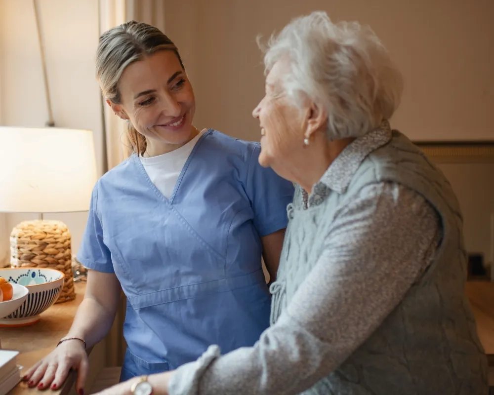 Companion caregiver talking with elderly woman