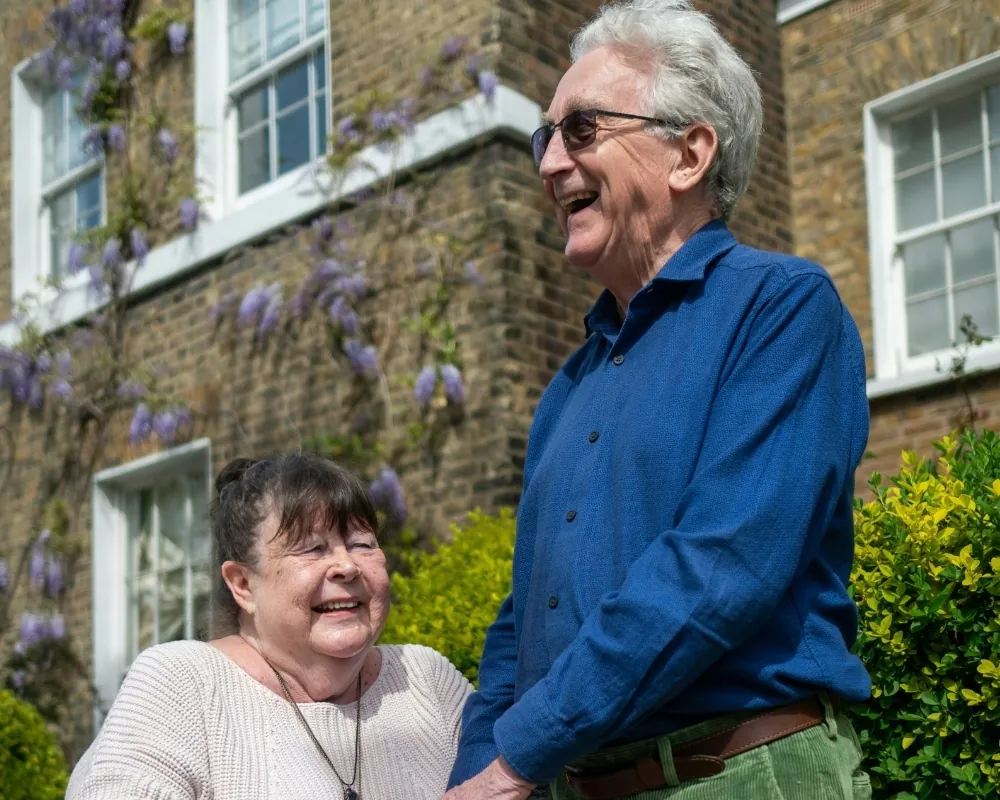 Happy senior couple outside home