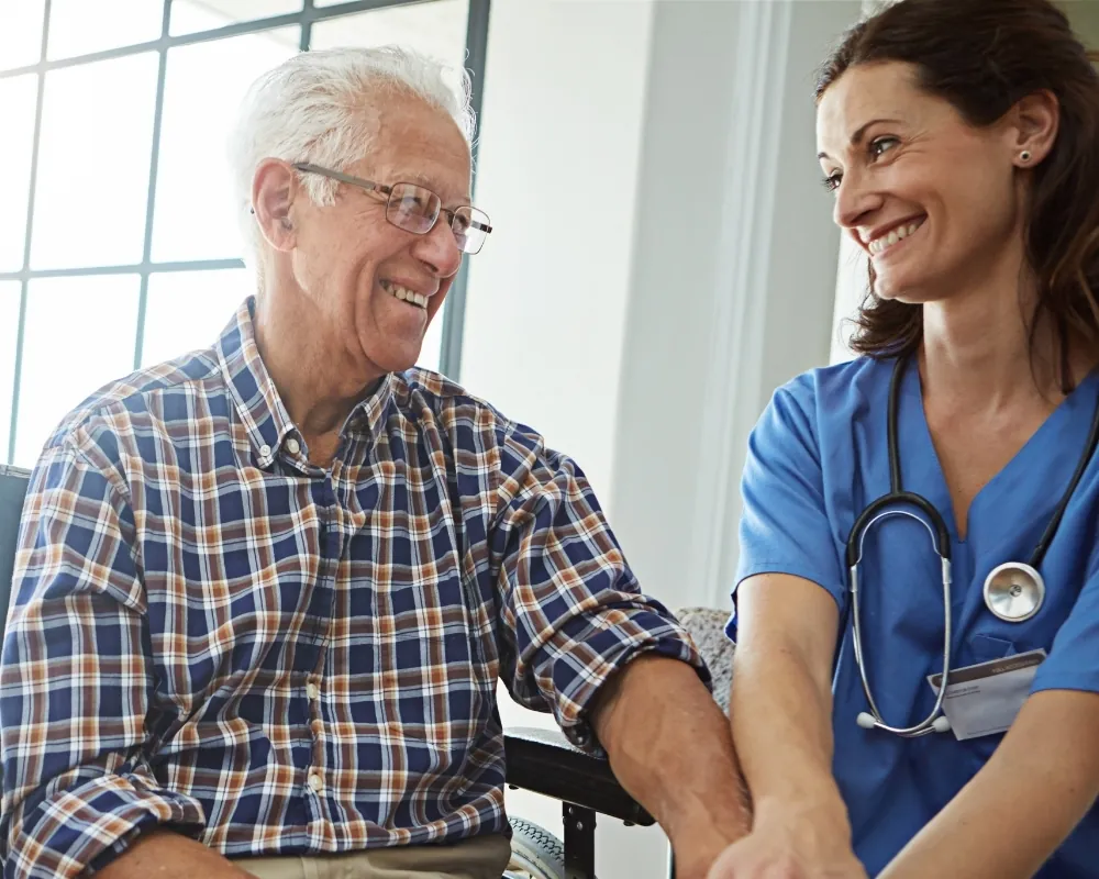 Home care nurse chatting with senior man
