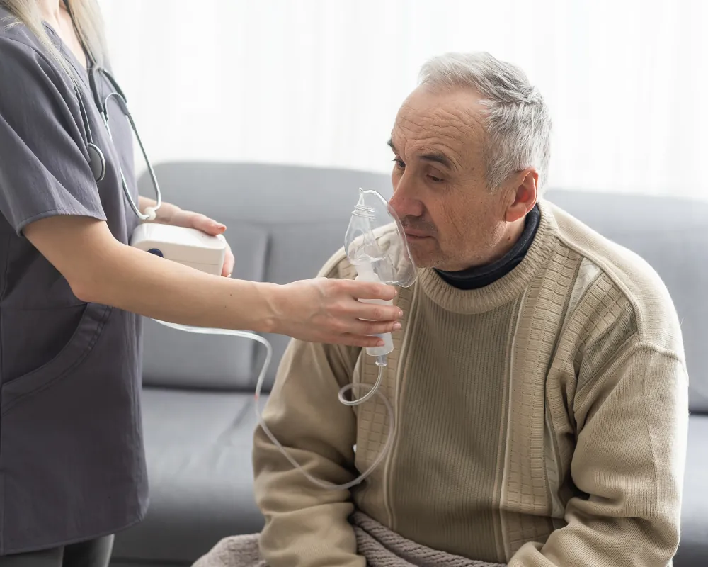 Nurse assisting senior with nebulizer treatment