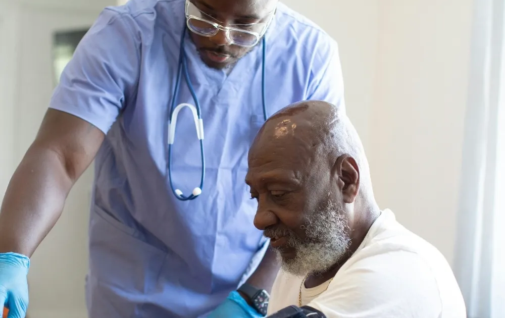 Nurse checking a senior man's blood pressure at home