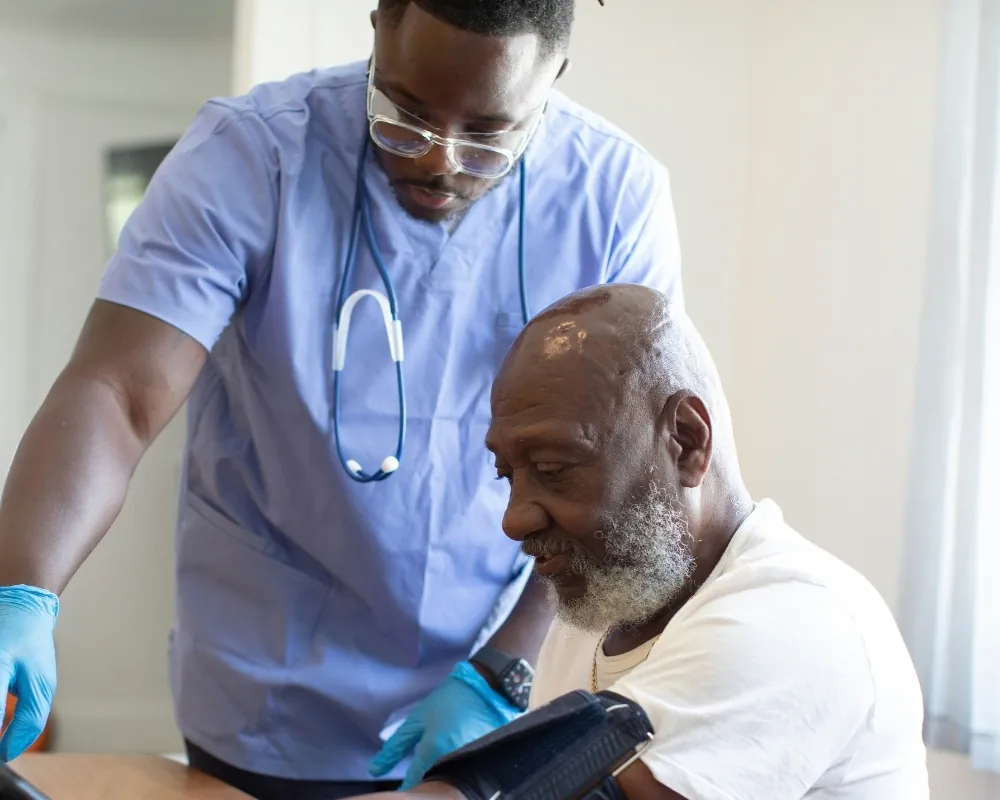 Nurse checking a senior man's blood pressure at home