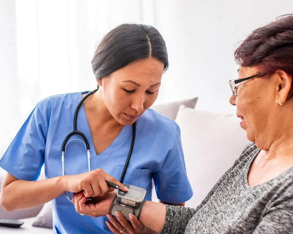 Nurse checking senior woman's blood pressure
