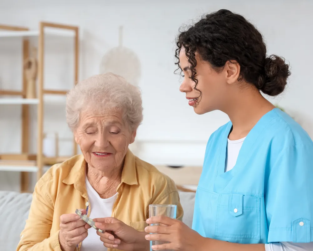 Nurse helping senior woman take medication