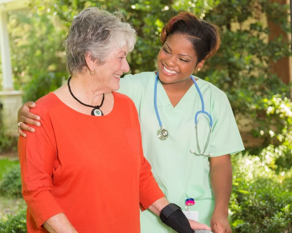 Nurse helping senior woman walk with crutch