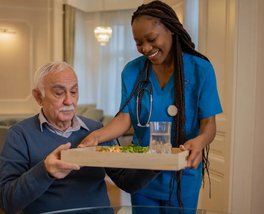 Nurse serving meal tray to senior man