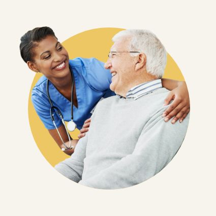 Nurse and elderly man smiling at each other