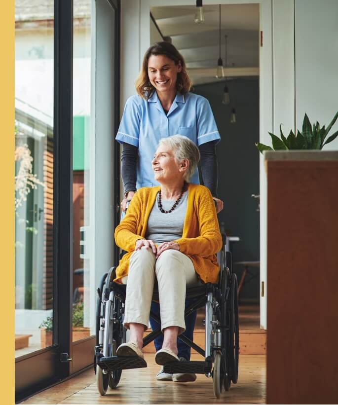 Nurse pushing an elderly woman in a wheelchair